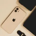 iPhone beside a laptop on a desk ahead of Apple earnings