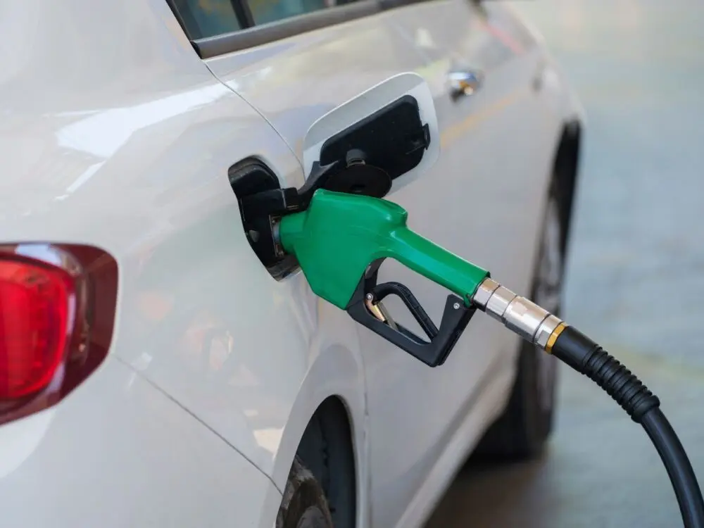 Green nozzle refueling a white car, a fill-up at current gas prices