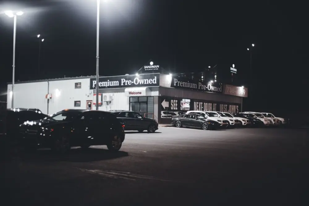 Illuminated car dealership lot at night, the dealer side of the Copart ACV acquisition