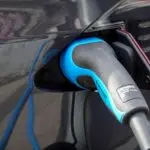 Electric car plugged into a charger, a Tesla earnings preview theme on deliveries and demand