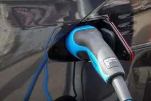 Electric car plugged into a charger, a Tesla earnings preview theme on deliveries and demand