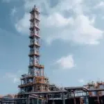 An oil refinery tower against a blue sky, a symbol of the refining profits in the Exxon Chevron Q3 results