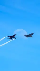 Two military fighter jets in a clear sky, a Lockheed Martin earnings theme