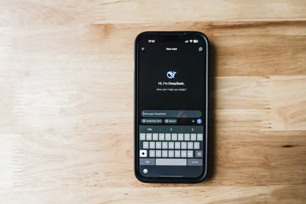 A smartphone on a wooden table showing an AI chat app, the kind of product at the center of the OpenAI lawsuit