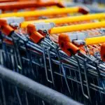 October consumer confidence and spending: orange handled shopping carts lined up in a store aisle