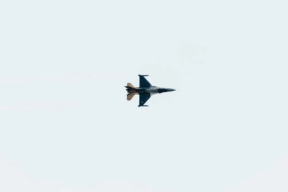 Military jet fighter in mid-flight against a clear sky