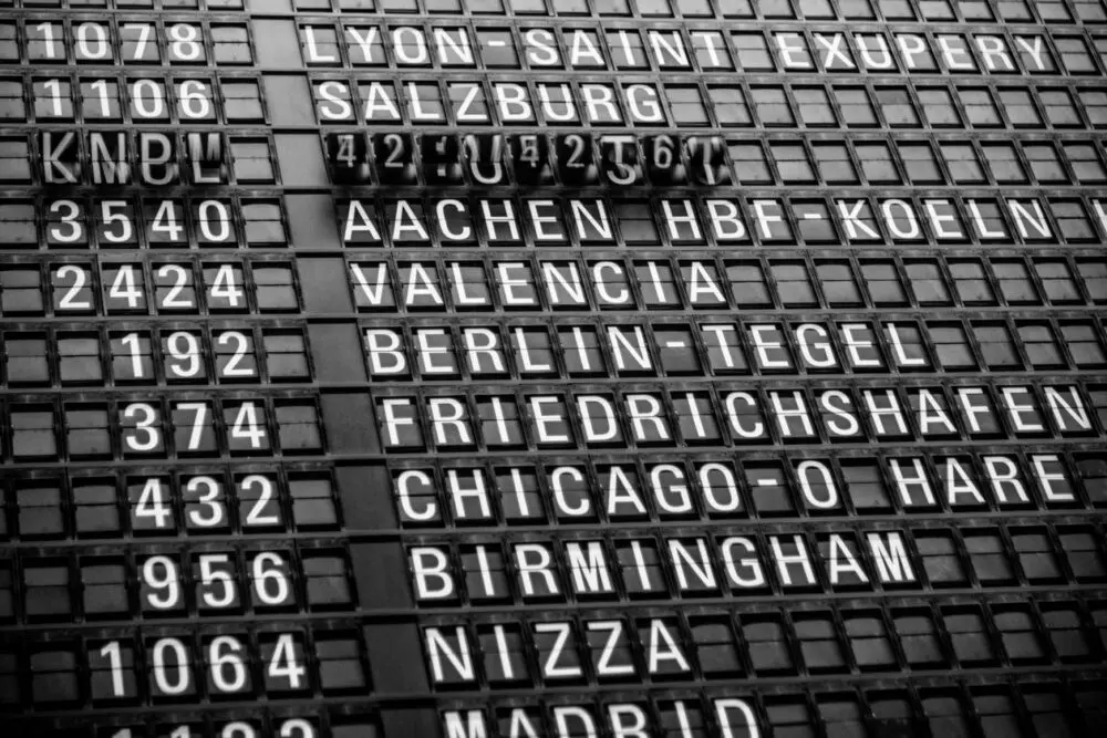 Split-flap airport departure board listing flights to European cities