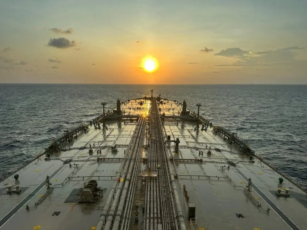 View along the deck of a large oil tanker at sunset, a symbol of Hormuz shipping risk