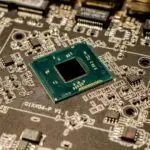 Close up of a microchip on a printed circuit board, as used in AI accelerators like Amazon TorchNeuron targets
