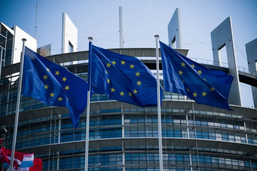 European Union flags waving outside a government building