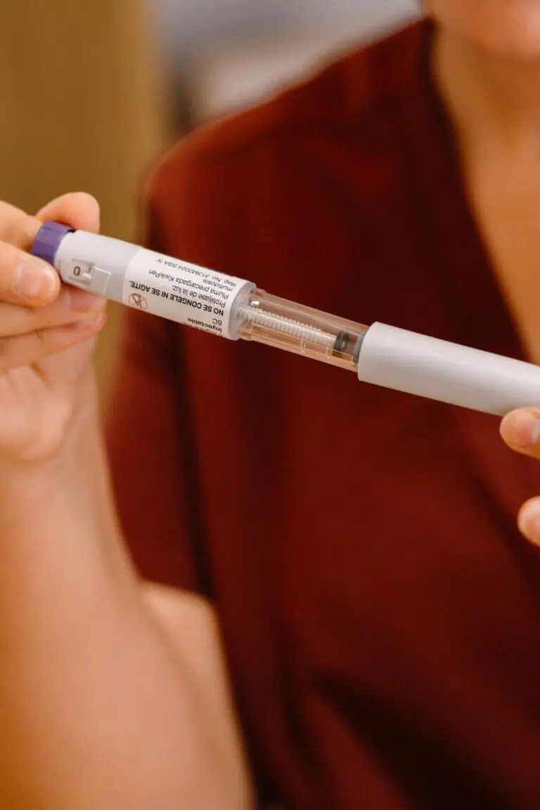 Hands holding a medication injection pen, illustrating the Eli Lilly Q3 earnings