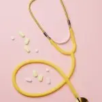 Stethoscope and medicines on a pink background, illustrating 2027 HSA limits