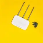 White wifi router on a yellow background, representing Comcast broadband