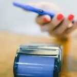 Person paying with a smartphone, as kids can with Google Wallet for Kids
