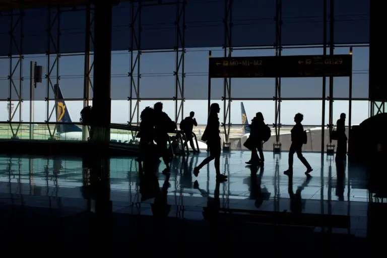 Silhouettes of travelers in an airport terminal, a scene where REAL ID requirements apply