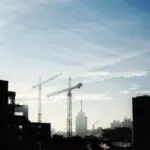 Construction cranes silhouetted against a morning sky, illustrating Q3 GDP investment and housing