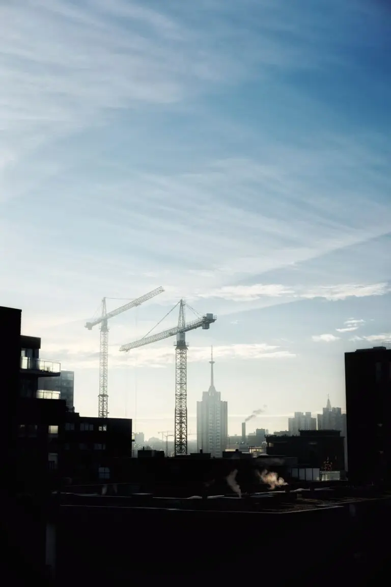 Construction cranes silhouetted against a morning sky, illustrating Q3 GDP investment and housing