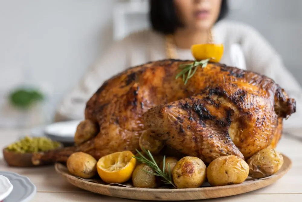 A roasted turkey on a wooden tray, the goal of getting turkey thawing times right