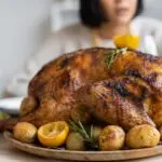 A roasted turkey on a wooden tray, the goal of getting turkey thawing times right