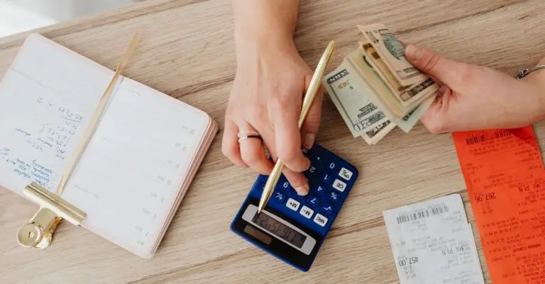 Person holding paper bills and a calculator while checking a bill under the No Surprises Act