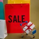 Colorful shopping bags and a mini cart with a gift, illustrating Black Friday 2026