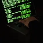 Green lines of code on a dark screen, illustrating Microsoft AI agent controls and security monitoring