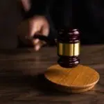 A judge's gavel striking a sound block, illustrating the OpenAI lawsuit filed by eight states
