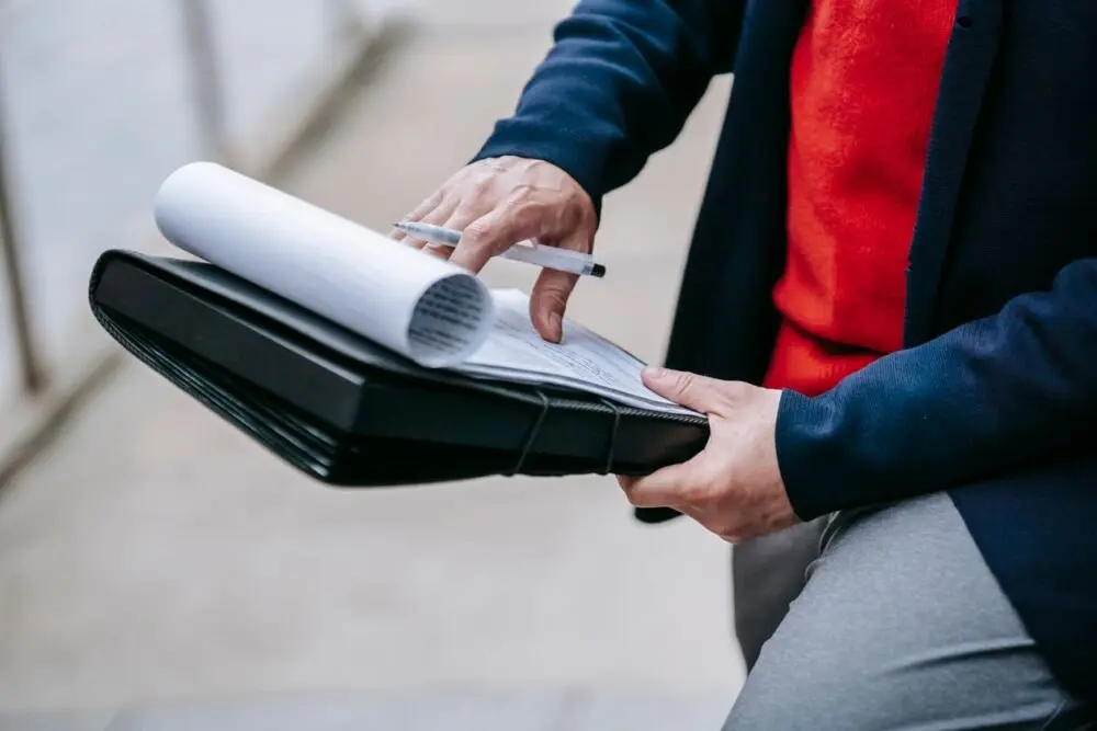 Person sorting documents in a portfolio, a reminder to keep records once you start an LLC
