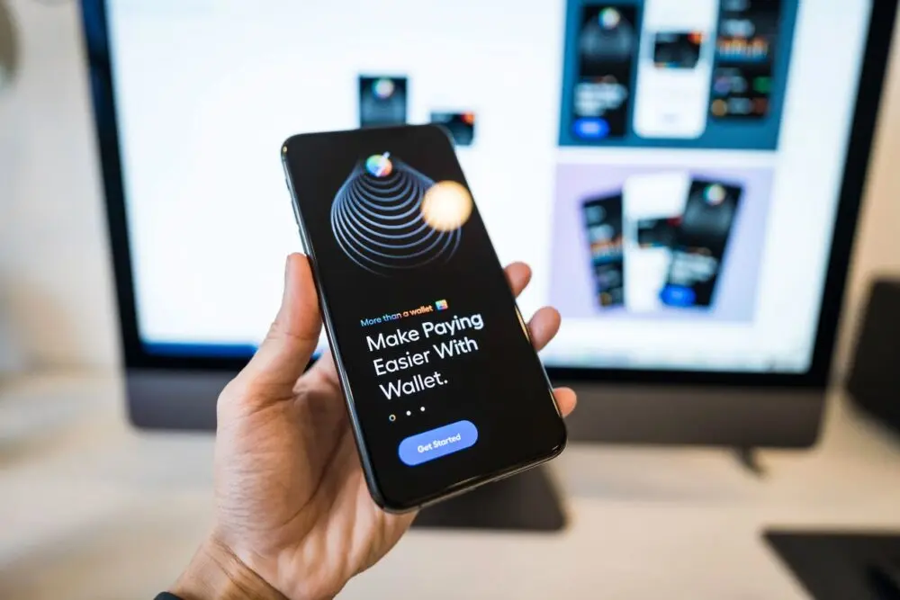 Hand holding a smartphone showing a digital wallet app for stablecoin holders