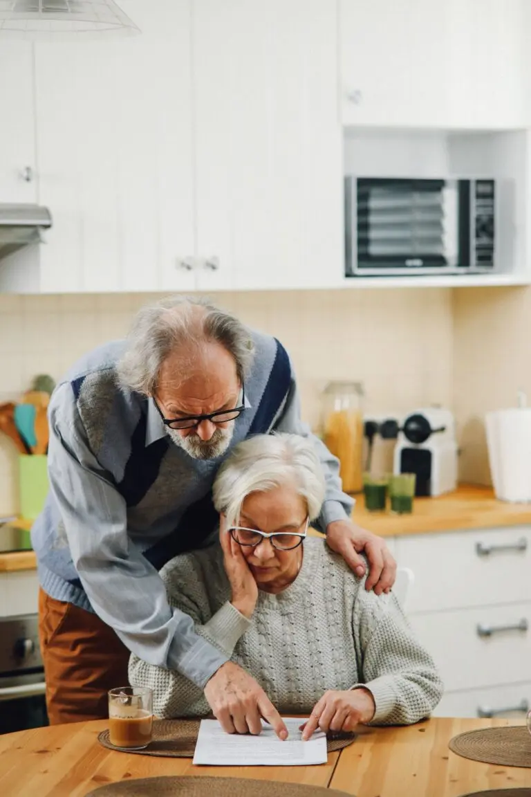 Elderly couple reading documents together at a kitchen table, illustrating the 2027 Social Security COLA