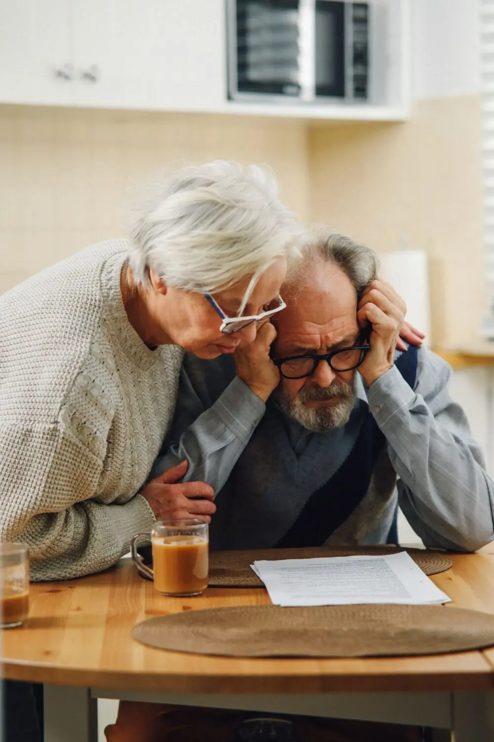 Senior couple studying documents on a kitchen table