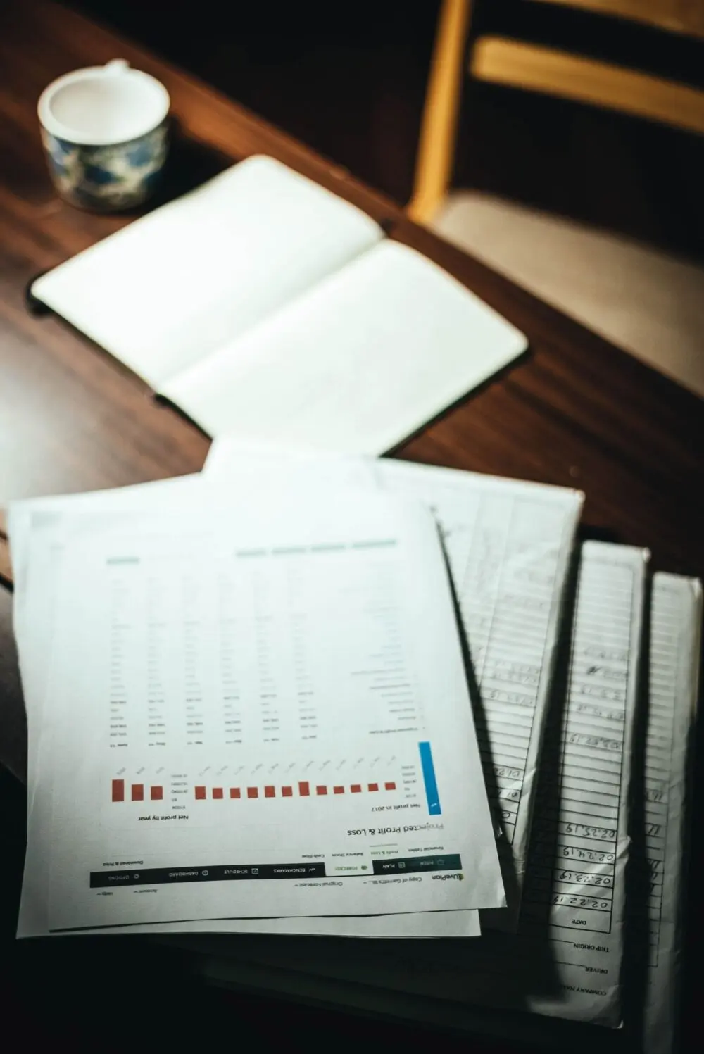 Financial documents and spreadsheets spread on a desk, representing private credit redemptions paperwork