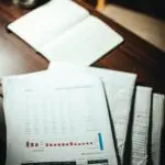 Financial documents and spreadsheets spread on a desk, representing private credit redemptions paperwork