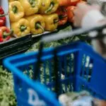 Shopper choosing bell peppers with a basket, a household using SNAP benefit amounts for groceries