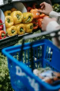 Shopper choosing bell peppers with a basket, a household using SNAP benefit amounts for groceries