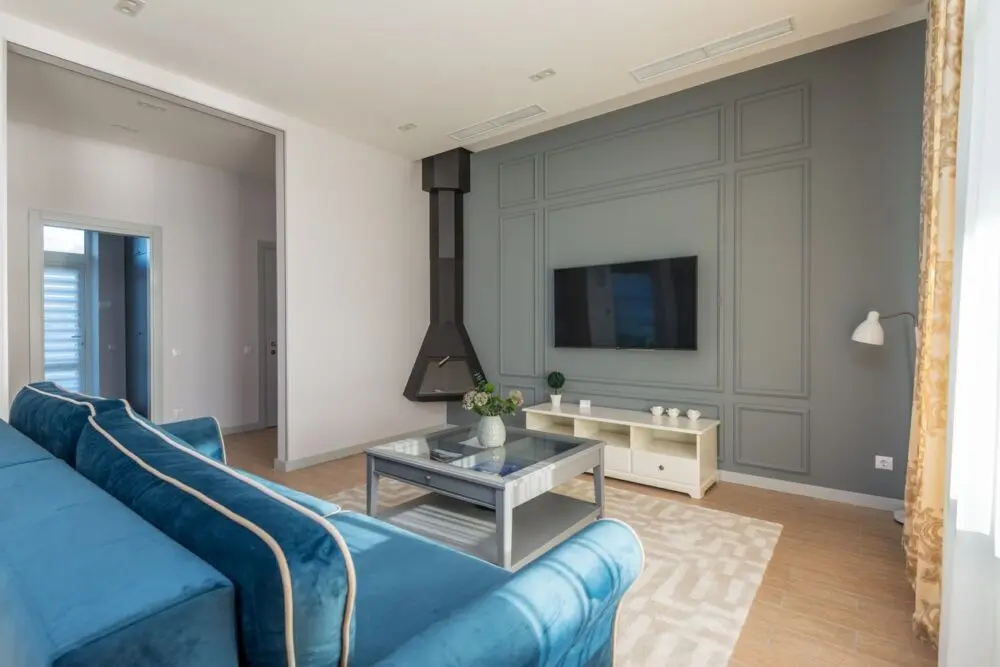 Living room with a wall-mounted TV and blue couch