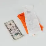 September PCE inflation and rising prices: a five dollar bill beside paper shopping receipts