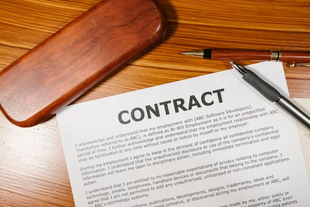 A contract and pen on a wooden desk, illustrating the Meta business terms customers need to review
