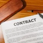 A contract and pen on a wooden desk, illustrating the Meta business terms customers need to review