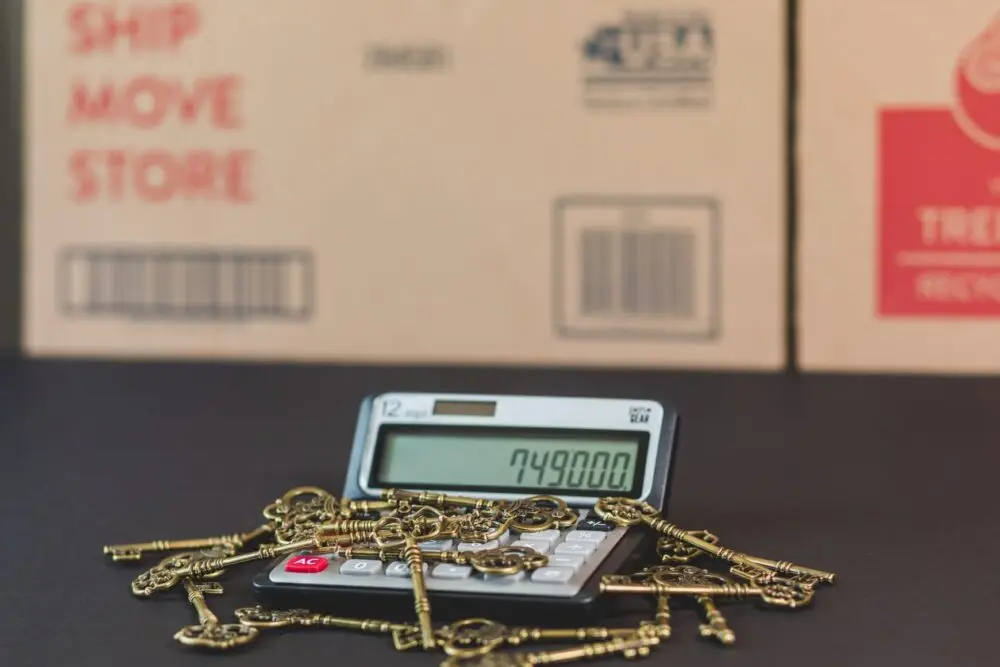 Calculator and vintage keys on a desk, representing the cost of buying a home as pending home sales fall