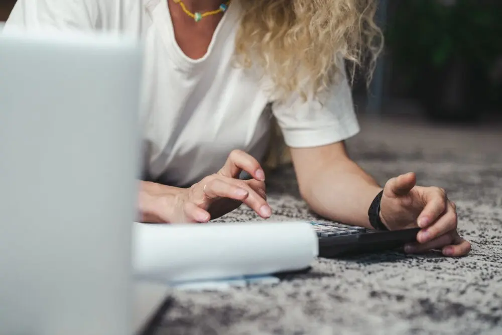 Woman using a calculator to compare monthly payments after a SAVE plan final notice