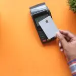 Disputing a credit card charge: person making a contactless credit card payment at a card reader