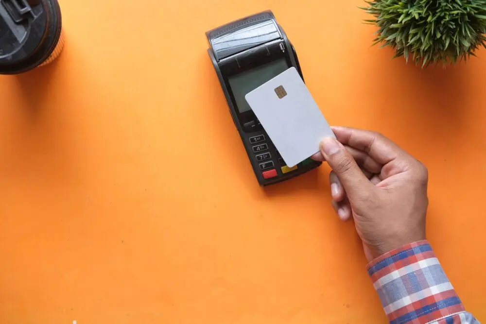 A contactless card payment at a terminal, illustrating what payments earnings reveal about spending