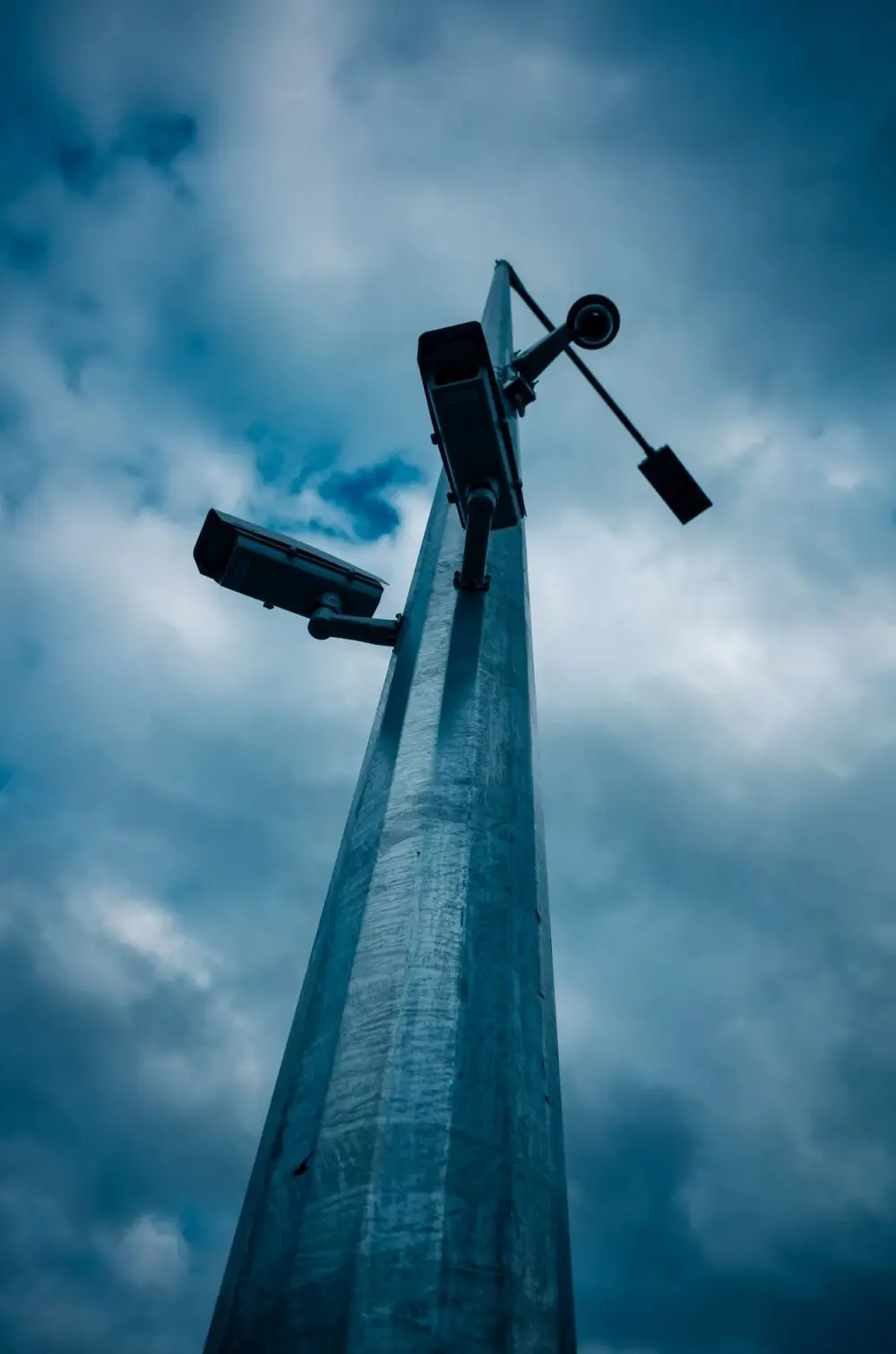 Surveillance cameras mounted on a tall pole, a sight cities weigh in Flock Safety contract votes