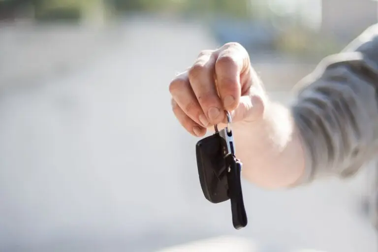 A hand passing a set of car keys to another hand