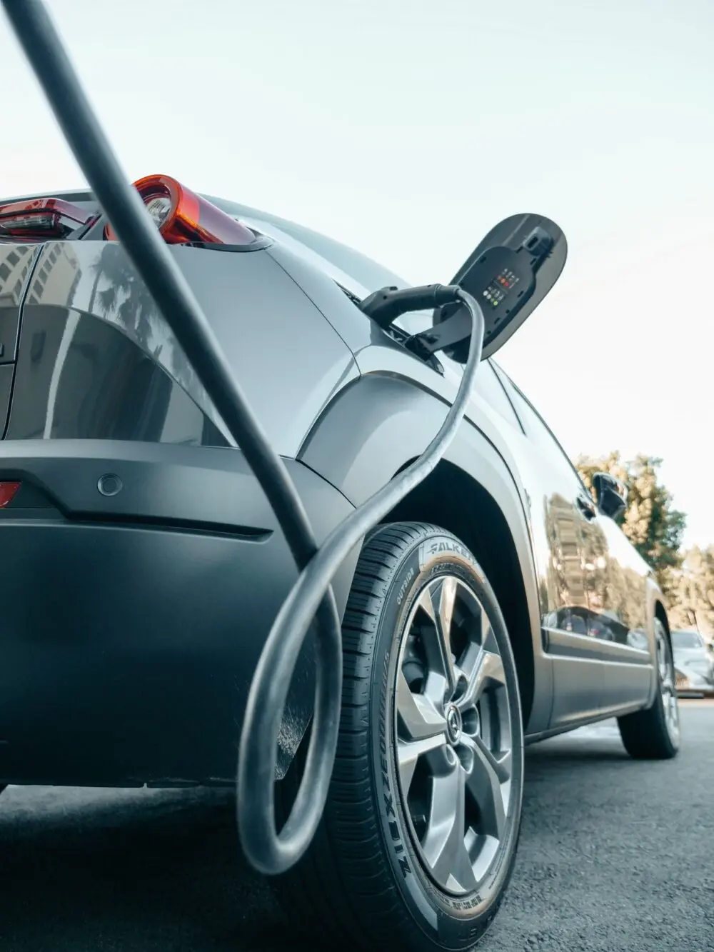 Electric vehicle charging at a station, illustrating Tesla's third-quarter deliveries