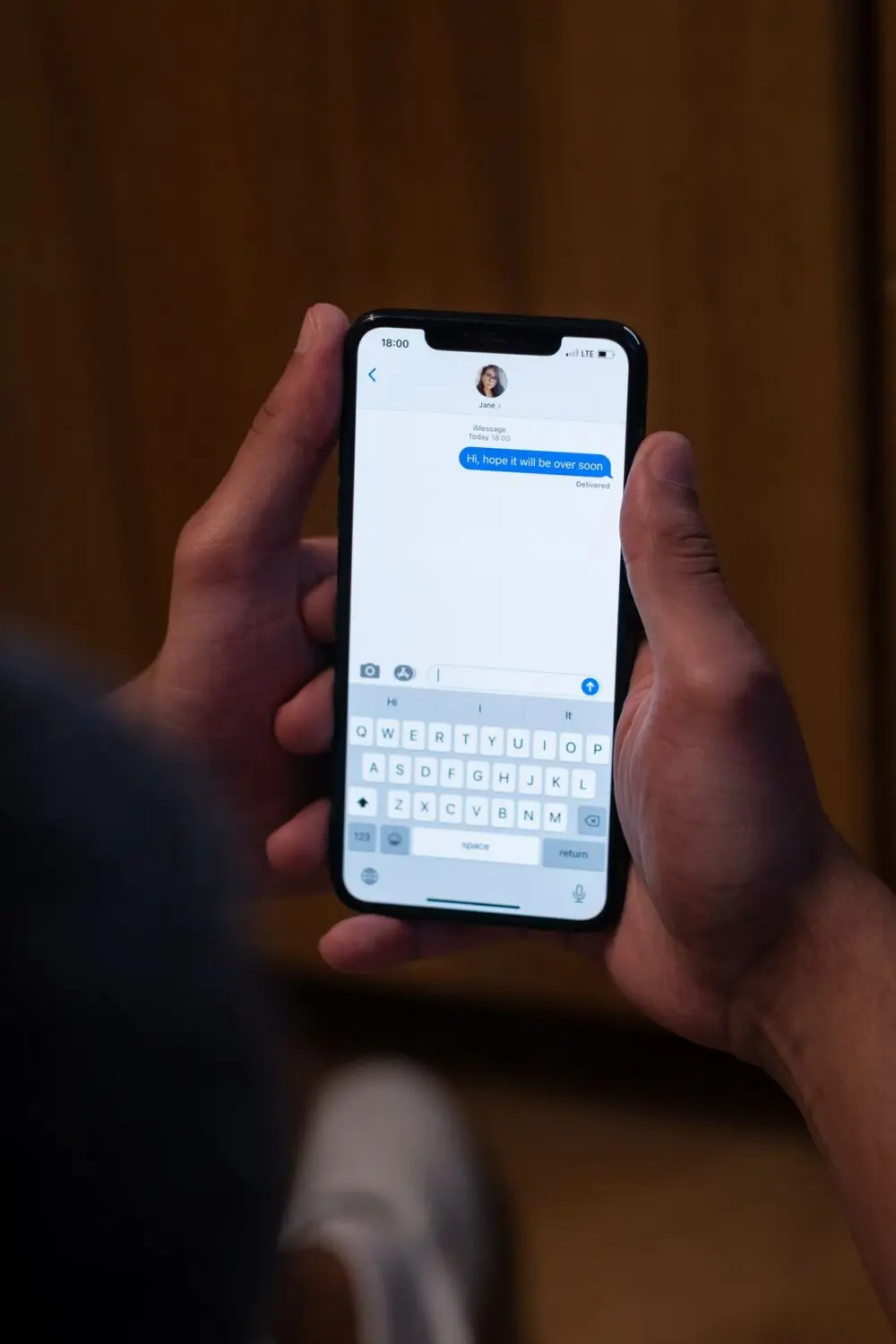 Hands holding a phone with a text conversation open, the first place to spot a scam text